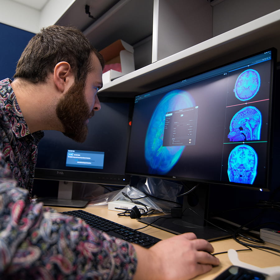 student in college of science and mathematics reviews brain scan imagery