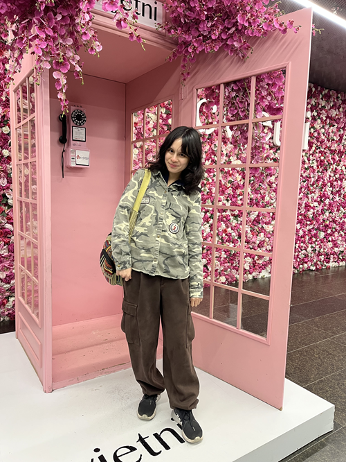 Mika student standing in front of pink phone booth